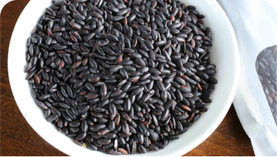 Shuddha Space organic black rice grains, showing a deep purple-black hue and matte texture.